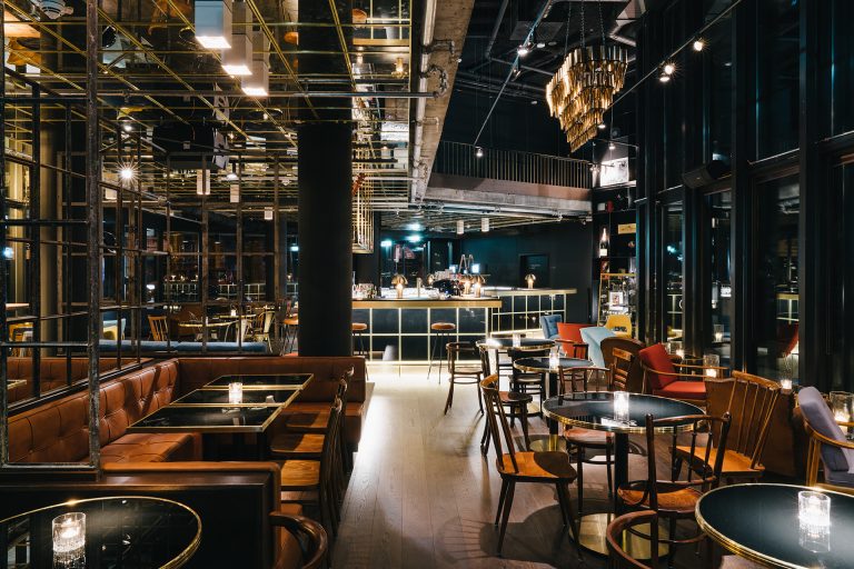 Das Bild zeigt die stilvolle Ruby Lilly Hotel Bar, ein modernes und luxuriöses Ambiente mit gedimmter Beleuchtung, hochwertigen Materialien und einer eleganten Bar. Ein Beispiel für modernes Hospitality-Design, optimiert durch digitale Lösungen für eine vernetzte Hotellerie.